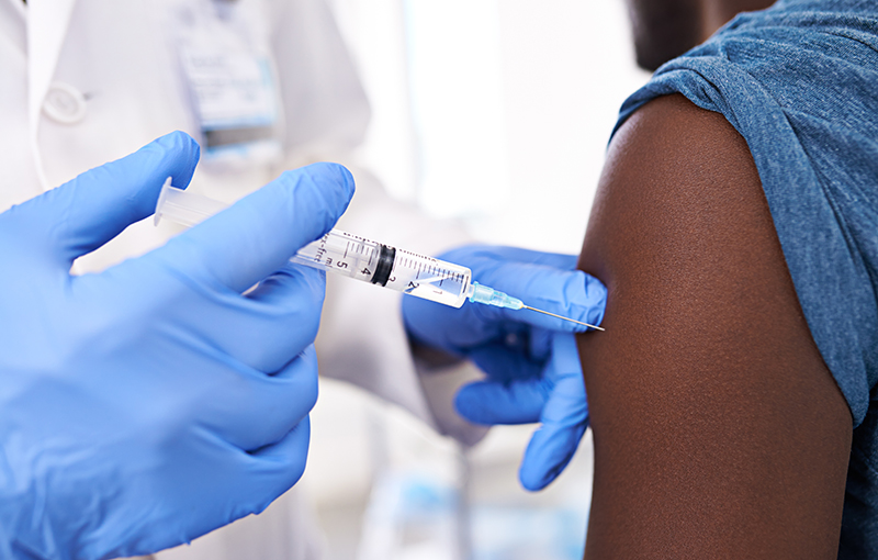 Closeup shot of a male patient receiving an injection from a doctor