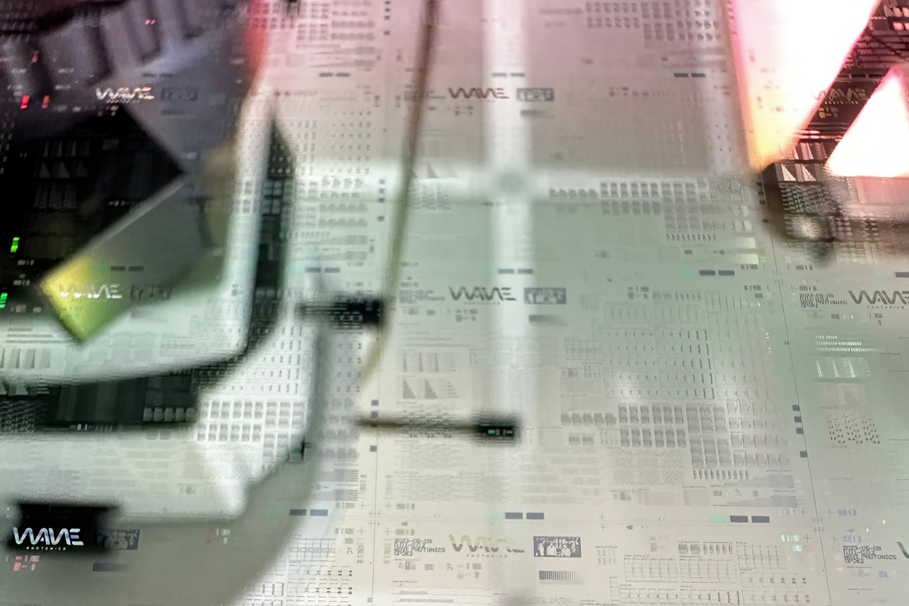A blurred and overlaid photograph of electronic equipment, possibly a synthesizer or audio mixer, with numerous buttons and sliders. The double exposure effect creates a visually intriguing and abstract look.