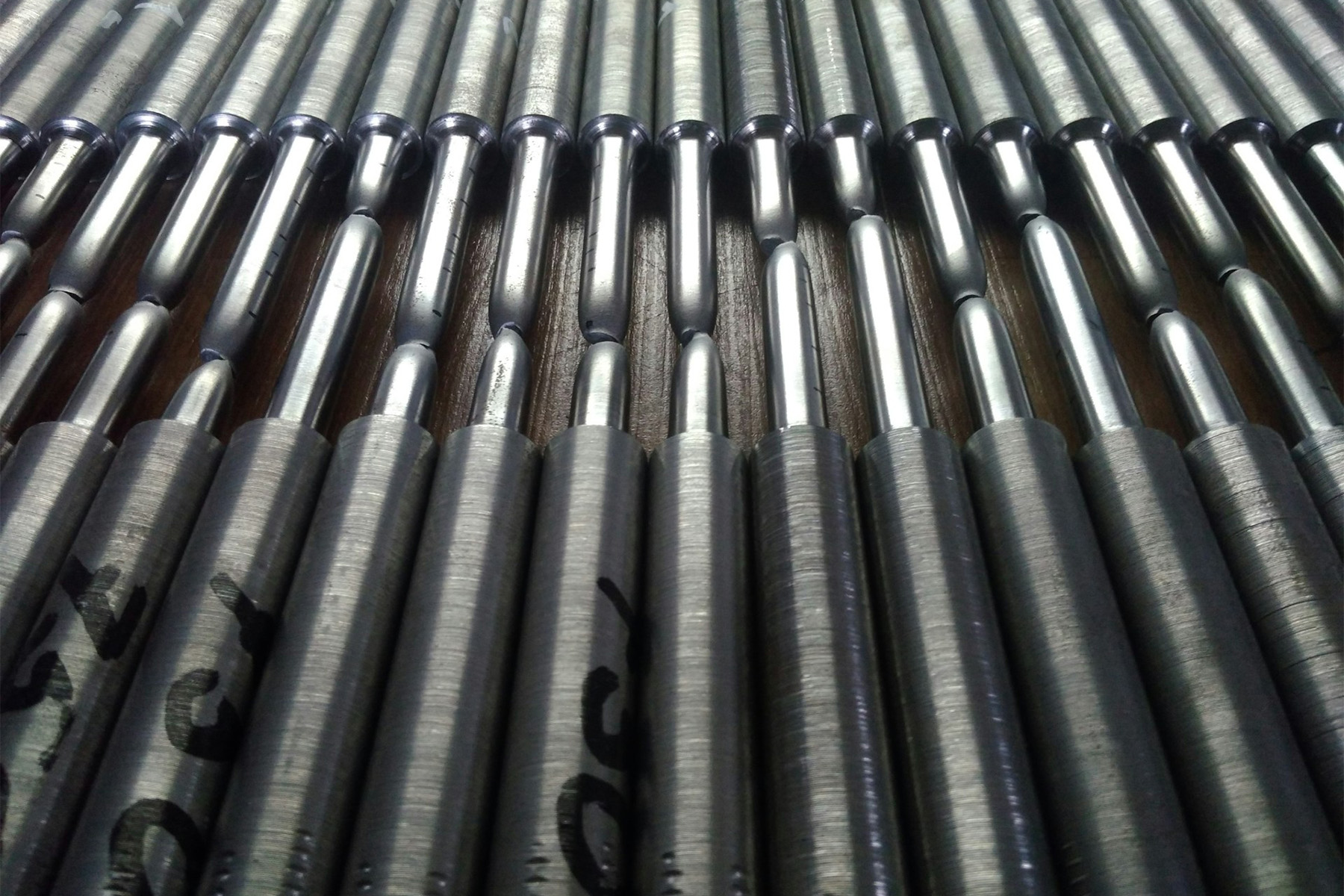 A close-up view of numerous cylindrical metal rods arranged in parallel, showcasing a repetitive pattern and industrial aesthetic.